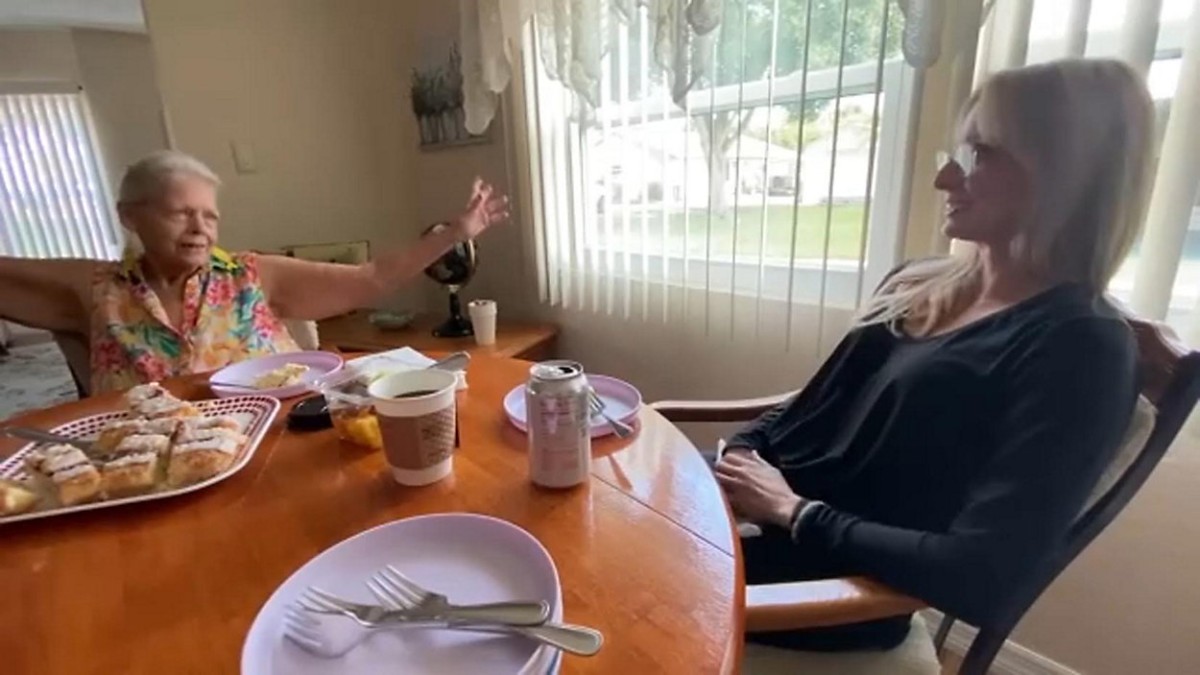 Health Buddies volunteer talking with an older adult at a kitchen table during a home visit in Tampa Bay