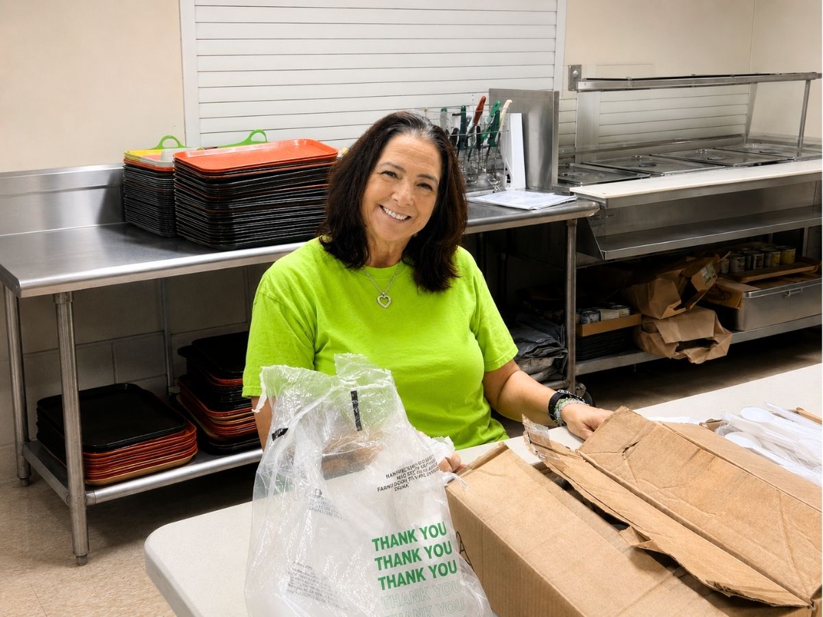 RSVP volunteer Ronnie prepares meal service at the Pasco County Senior Center in Land O'Lakes, supporting local seniors with a warm smile.