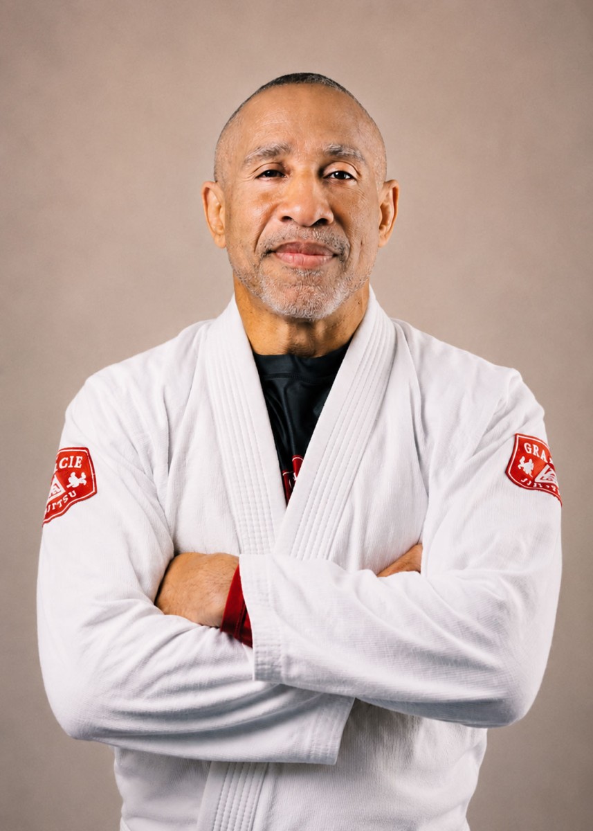 Saulo, a jiu-jitsu instructor and Operation: Veteran Connect volunteer, stands with arms crossed in his martial arts uniform.
