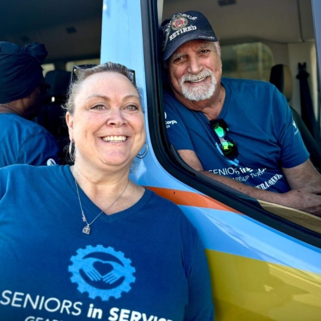 Seniors in Service Van at Tampa Bay Community Event Seniors in Service staff smile near the SIS van at a community event.