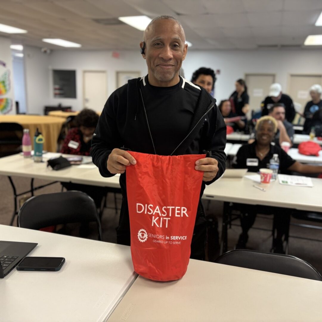 Seniors Disaster Support Volunteer Shows Disaster Kit A Seniors in Service volunteer shows the branded Disaster Kit.