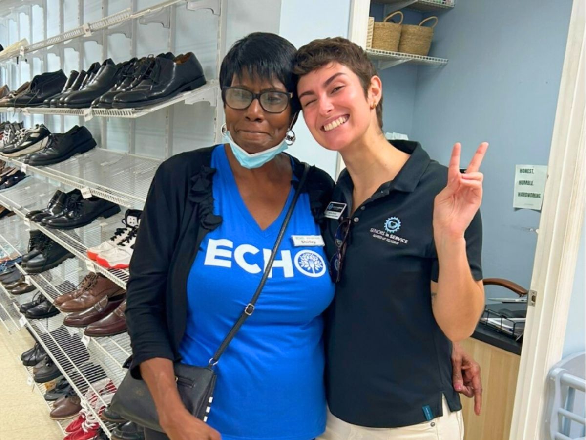 Shirley, a Seniors in Service volunteer, stands with a staff member at ECHO&rsquo;s Resource Center in Brandon, helping families access clothing and essential resources.